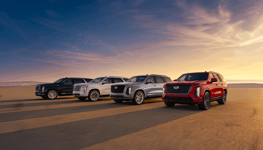 Cadillac Escalade lineup driving across a desert road at sunset, showcasing the MY25 models imported and distributed by AEC in Europe.
